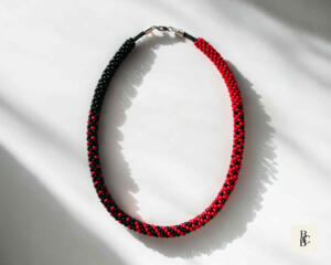Crimson Noir Kumihimo beaded necklace by Bead & Braid Collective in red and black glass seed beads on white background
